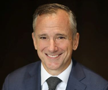 A man in a suit and tie smiling.