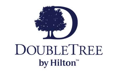 Logo of DoubleTree by Hilton featuring a stylized tree within a "D" shape. "DoubleTree by Hilton" is written below in dark blue text.